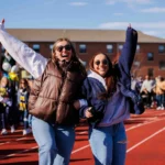 Students on campus track smiling